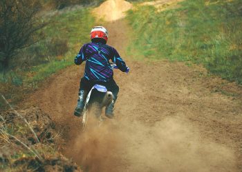 Man Riding Motocross Dirt Bike on Dirt Road