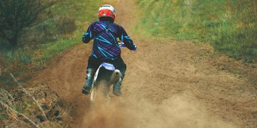 Man Riding Motocross Dirt Bike on Dirt Road