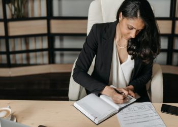 Brunette Woman Sitting by Desk and Writing