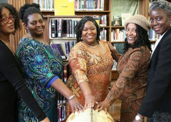 Five Women with Hands on top of a Wooden Globe